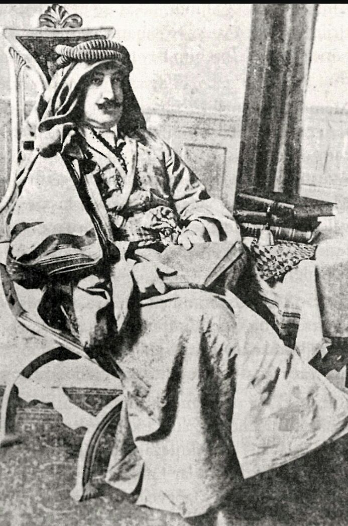 A newspaper portrait of Abdürrezzak Bedirhan seated in an ornate chair, wearing a wrapped head covering, long robes and a decorated belt