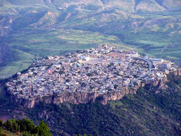 Amêdî’s buildings and minaret cover a steep-sided rocky plateau above a green mountain valley