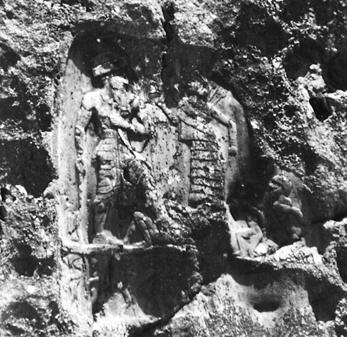 Black-and-white historical photograph of Anubanini’s relief, with the king, goddess, lower captives and inscription visible