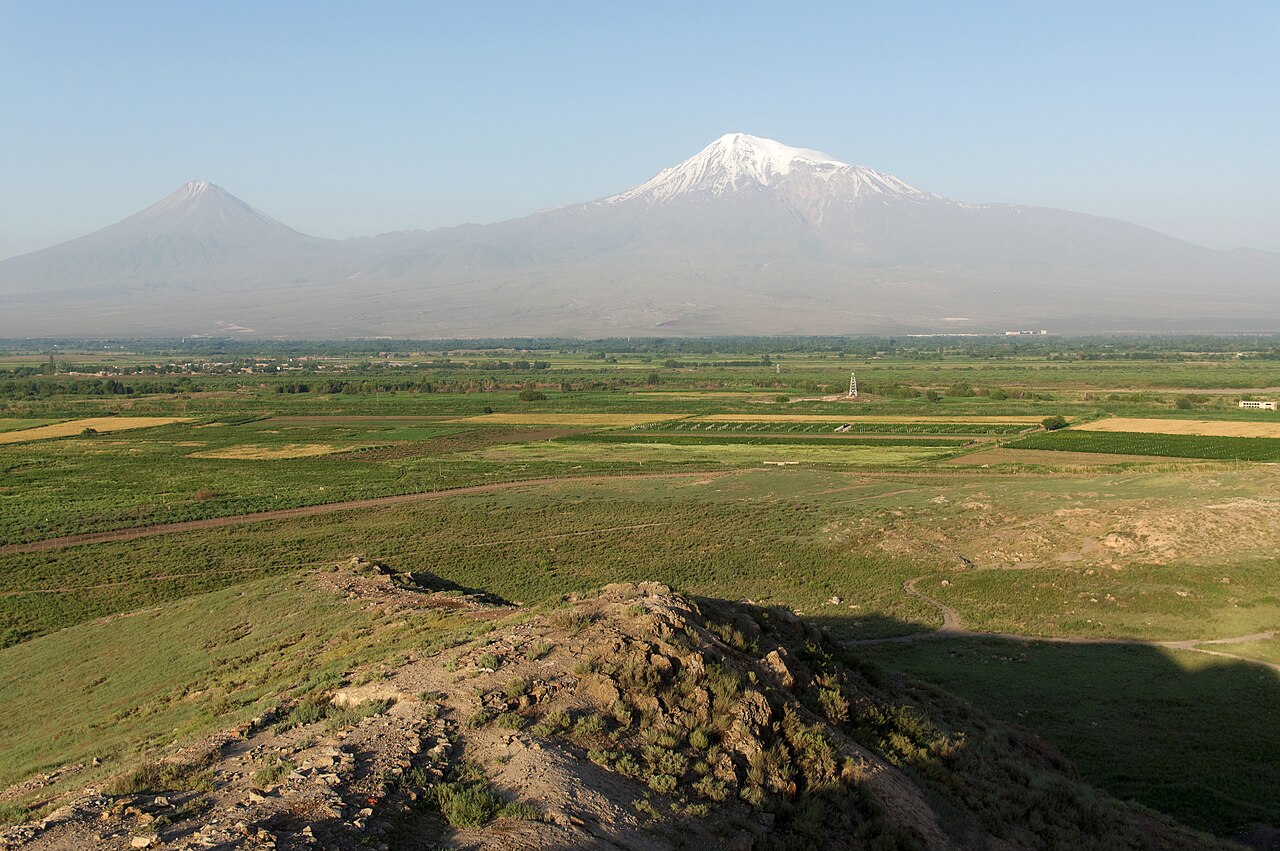 Agiriyê Mezin bi lûtkeya berfî li rastê û konê biçûk ê volkanî li çepê li jor zeviyên kesk ên deştê