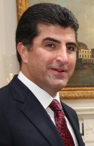 Nechirvan Barzani i mörk kostym, vit skjorta och mönstrad röd slips under Londonbesök i maj 2014