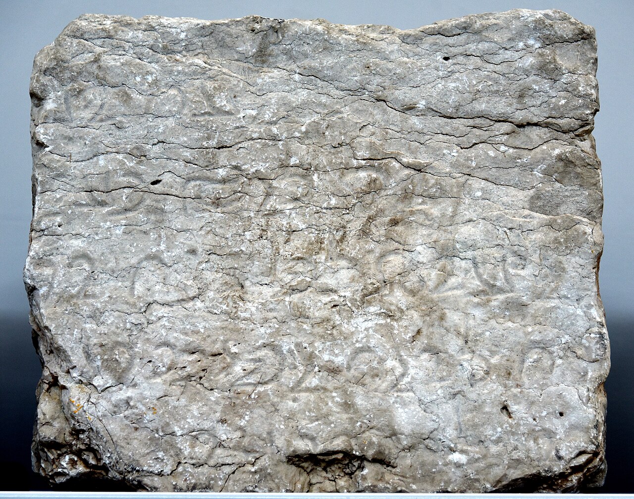 Weathered rectangular stone block B7 from Paikuli with rows of carved Middle Persian letters, displayed in the Slemani Museum