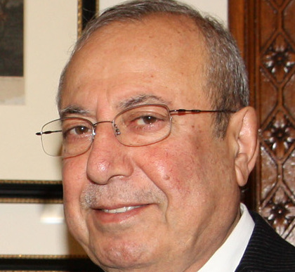 Roj Nûrî Şaweys bi berçavk û cilên tarî di serdana Londonê ya Îlona 2011an de dikenî