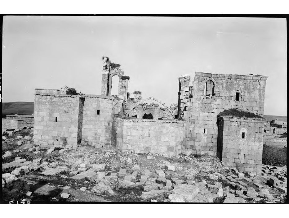 Ruined stone walls and rounded exterior forms of El Adra church at Silvan in a black-and-white photograph