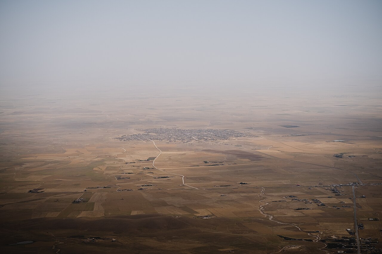 Fields, roads and a settlement on the plain north of Sinjar Mountain, seen from the Chil Mera shrine