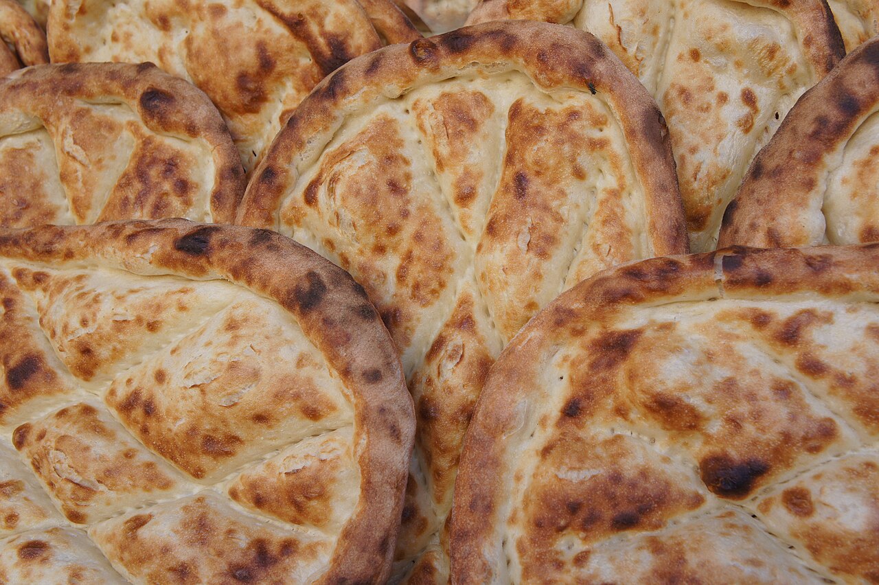 Overlapping round breads with browned edges, blistered surfaces and pressed patterns, photographed in Bismil