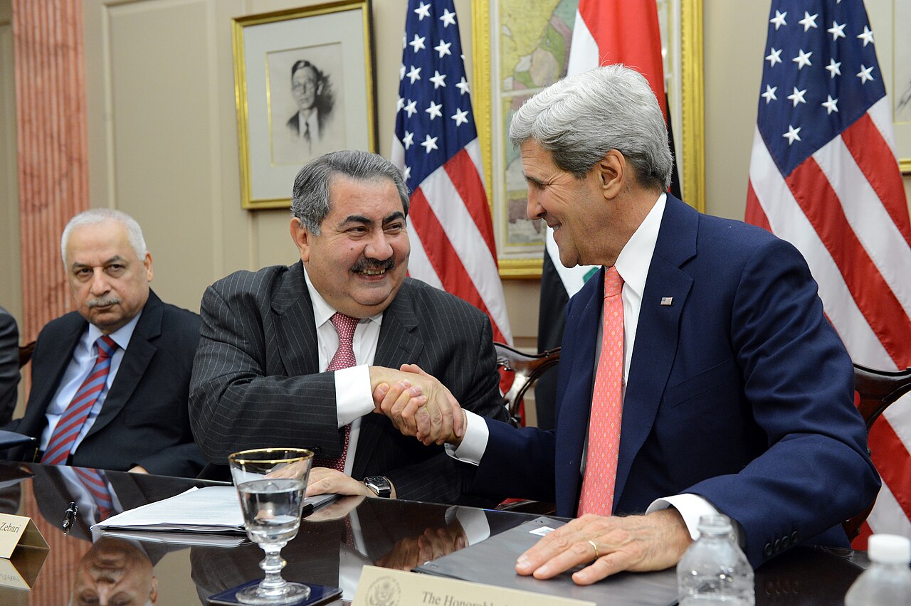 Hoşyar Zêbarî li çepê li ser maseya civînê bi John Kerry re dest dide hev li ber alên Iraq û Amerîkayê